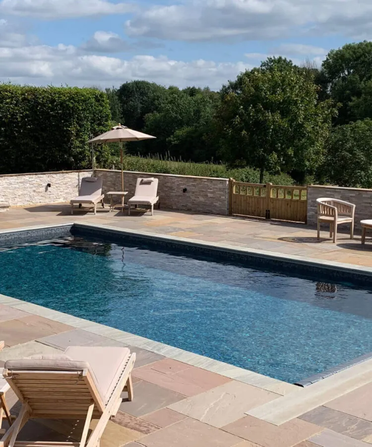 A classic style outdoor Falcon Pool with patio furniture
