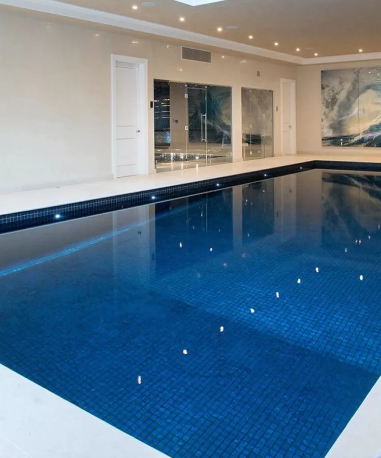 A luxury indoor Falcon Pool with dark blue finishing and a gentle slope