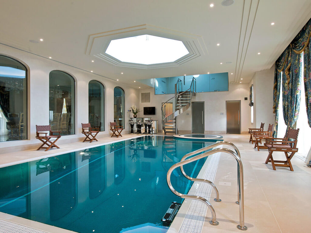A large indoor Falcon Pools swimming pool with a skylight.