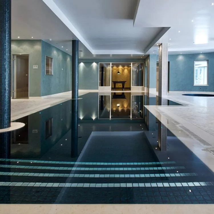A luxury indoor Geometric Falcon Pool with dark blue pool finishing and tiled pillars